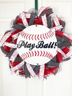 a baseball wreath with the word play ball on it hanging from a door handle that is decorated with red, white and black mesh