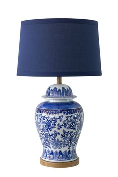 a blue and white table lamp with a blue shade on the top, against a white background