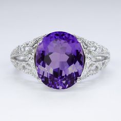 This vintage style ring features an amethyst set in a sterling silver setting. The Art Deco style setting is beautifully crafted with flower accents and curling filigree details. The oval amethyst is a natural, earth mined stone. The ring measures 12mm across (north south) and 8.5mm from finger to top. Please note that colors can vary slightly depending on your monitor and display settings. The video features this setting with a swiss blue topaz center. This version is also available in our shop Amethyst Set, Vintage Style Rings, Amethyst Color, Purple Band, North South, Sterling Silver Filigree, Swiss Blue Topaz, Natural Earth, Silver Filigree