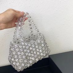 The Eva Diamonds Handbag exudes elegance and sophistication, featuring large rhinestones carefully arranged against a beautifully beaded exterior. Its comfortable handle ensures easy carrying, while the spacious interior accommodates all your essentials with style and grace. Perfect for matching with a variety of outfits, this bag seamlessly transitions from day to night, adding a touch of sparkle to any ensemble. Exclusively available in white. Evening Handheld Bags With Bling, Silver Bags With Rhinestones For Everyday Use, Chic Shoulder Bag With Rhinestones For Everyday Use, Crystal Handheld Evening Bag, Elegant Embellished Bags, Chic Everyday Shoulder Bag With Rhinestones, Top Handle Shoulder Bag With Rhinestones For Everyday, Chic Evening Crystal Bags, Chic Handheld Evening Bag With Rhinestones