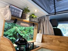 the interior of a camper with potted plants and other items on the shelf