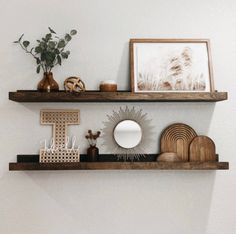 two wooden shelves with decorative items on top and one shelf holding a mirror, vases and other objects