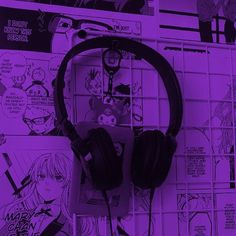 headphones are sitting on top of a table with comic pages in the back ground