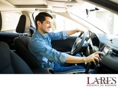 a man sitting in the driver's seat of a car with his hand on the steering wheel