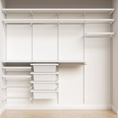 an empty walk in closet with white shelving and bins on the wall next to it