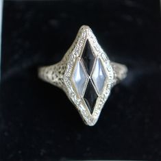 Art Deco 14k white gold moonstone and onyx ring.  A harlequin design consisting of elongated diamond shapes adds interest along with the beaded border and filigree design. Materials - 14k white gold, moonstone and onyx. Hallmarks - 14 on the inside shank. Condition - Very good vintage condition. Measurements - Ring size is 6 3/4.  The front of the ring is 7/8" long and 1/2" wide. Filigree Design, Deco Jewelry, Onyx Ring, Art Deco Jewelry, Rings Statement, Shopping List, Diamond Shapes, Moonstone, Statement Rings