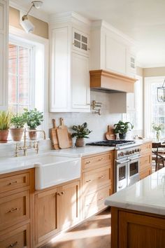 a kitchen filled with lots of wooden cabinets and white counter tops next to a stove top oven