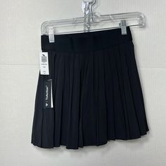 This Is A Pleated Tennis Skirt With Built-In Undershorts, Functional Ball Pockets And An Elastic Waistband. The Undershorts Are Made With Tnaslick A Sweat-Wicking, Breathable Fabric With A Slick, Cool Touch And Sculpting Feel. The Skirt Is Made With Tnamove Lightweight, Sweat-Wicking Fabric With A Smooth, Cool Feel And A Natural Drape That Moves With You. This Fabric Is Made With Recycled Materials. Features High-Visibility Spiro Built-In Undershorts Functional Ball Pockets Materials & Care Cont Fitted Black Pleated Shorts, Sporty Black Mini Skirt, Black Pleated Tennis Skirt For Sports, Black Skirted Pleated Shorts, Black Tennis Skirt With Short Inseam And Lining, Black Stretch Pleated Shorts, Black Lined Short Tennis Skirt, Sporty Black Short Mini Skirt, Sports Black Pleated Skort