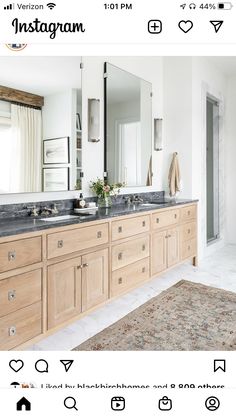 a large bathroom with double sinks and mirrors on the wall, along with an area rug