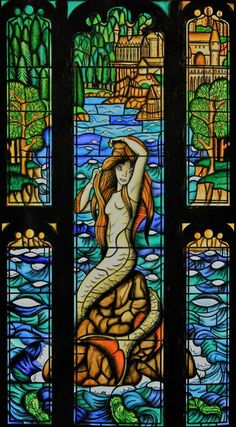 a stained glass window with a mermaid on it's body and water in the background