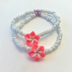 this bracelet is made of strong, stretchy string! the pink plumeria beads adds just enough color to the bracelet and gives it a beachy accent! the bracelet will come in a small drawstring mesh pouch that coordinates to the product's color! stickers, candy, business cards, thank you notes, and extras may also be included :) DM me on Instagram @beaded.by.clara, email me at beadebyclara@gmail.com, or contact me through etsy for custom sizes, questions, or more info!! Handmade Flower Beaded Bracelets For Vacation, Flower Shaped Beaded Bracelets For Beach, Pink Round Beads Friendship Bracelets For Vacation, Pink Flower Friendship Bracelets With Tiny Beads, Handmade Pink Beaded Strand Bracelets, Pink Beaded Friendship Bracelets For Vacation, Adjustable Flower Beaded Bracelets For Beach, Casual Beaded Bracelets With Flower Beads For Beach, White Flower Bracelets For Vacation