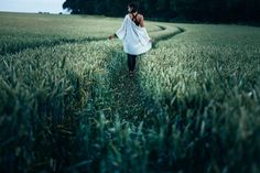 a woman walking through the middle of a field