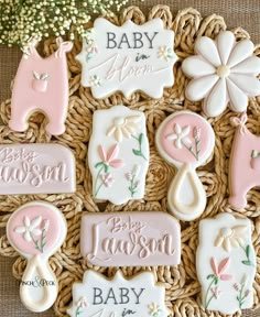 baby shower cookies are arranged on a wicker basket