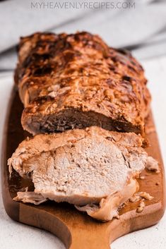 sliced meatloaf sitting on top of a wooden cutting board