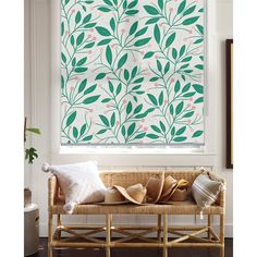 a living room with a couch and window covered in green leafy blinds on the windowsill