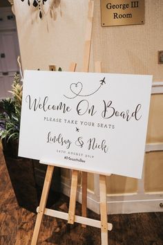 a welcome on board sign sitting on top of a wooden easel