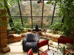 a living room filled with lots of plants and furniture