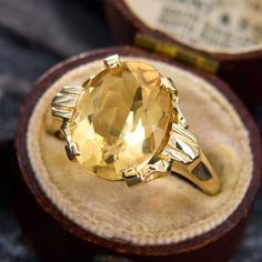 an oval yellow topaz ring sits in a box