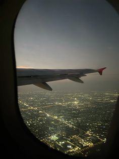 an airplane wing over a city at night