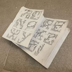 two pieces of paper with letters and numbers drawn on them sitting on the ground next to each other