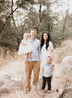 a family poses for a photo in the woods