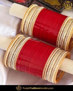 two red and gold bangles are sitting next to each other