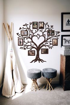 a family tree is hanging on the wall next to two stools and a teepee