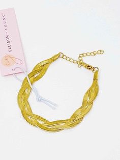 Get ready to add a twist to your style with this Add a Braid or Two Herringbone Braided Bracelet! This unique piece features not one, but three herringbone chains that are beautifully braided together for a stunning look. And with its comfortable fit on the wrist, you'll never want to take it off! Color: Gold Made of: Stainless steel, 18K gold plated. Brand: Ellison and Young Includes: x1 BraceletDimensions: 6-inch long with a 2-inch extender. Tarnish and water-resistantLead and Nickel Free. Braided Metal Bracelets As Gift, Gold Metal Braided Bracelets, Adjustable Multi-strand Chain Bracelet Gift, Elegant Adjustable Braided Jewelry, Trendy Braided Jewelry, Adjustable Braided Gold Jewelry, Adjustable Gold Braided Jewelry, Adjustable Braided Bracelet With Lobster Clasp, Herringbone Braid