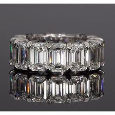 an emerald cut diamond ring with three rows of baguetts in the middle and two rows