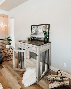 a living room with white walls and wood flooring on the wooden floor is an animal cage