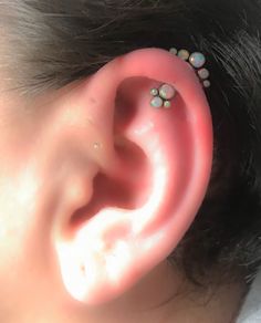 a close up of a persons ear with some piercings on it's side