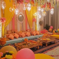 a decorated room with balloons and flowers on the ceiling, couches and tables in front of them