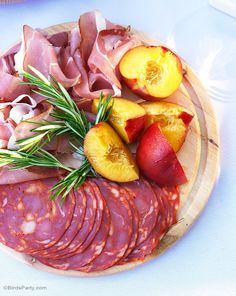 a wooden plate topped with meat and fruit