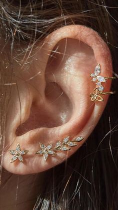 a close up of a person's ear with two small flowers on the side