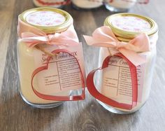 two jars with labels on them sitting on a table