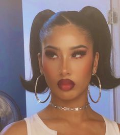 a woman with large hoop earrings and red lipstick