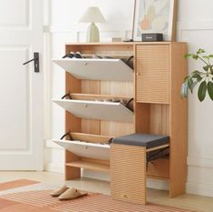 a wooden shelf with three white plates on it and a plant in the corner next to it