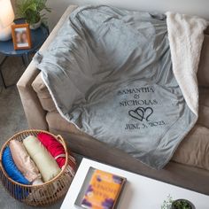 a living room with a couch, coffee table and blanket on top of the couch