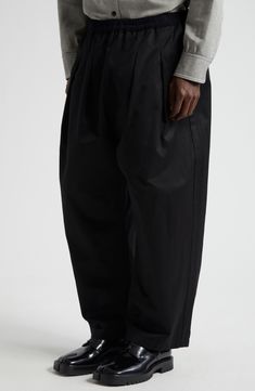 A voluminous pleated silhouette inspired by skating culture enhances the easygoing style of these baggy-fit chinos topped with an elastic waist. Elastic waist Side-seam pockets; back patch pocket 100% cotton Dry clean Made in Italy Designer Clothing Casual Black Bottoms With Pleated Waist, Fall Black Bottoms With Pleated Waist, Casual Black Pleated Pants, Black Casual Pleated Pants, Black Parachute Pants With Elastic Waistband And Tapered Leg, Relaxed Fit Washed Black Pants With Multiple Pockets, Black Pleated Tapered Leg Pants, Black Relaxed Fit Pleated Bottoms, Streetwear Ankle-length Parachute Pants With Elastic Waistband