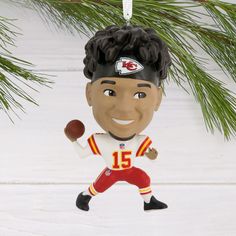 a christmas ornament with a football player holding a ball in it's hand