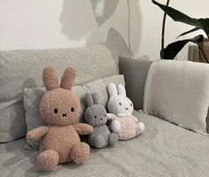 three stuffed animals are sitting on the couch