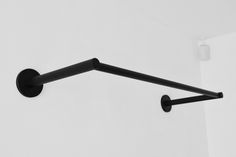 a black towel rack on the wall with two handles and one arm hanging from it's side