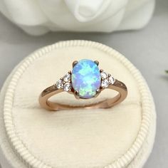 This beautiful ring is made from genuine 925 sterling silver with rose gold plating. Ring details- -The Main stone is an oval cut 8mm by 6mm Lab Created Light Blue Opal Stone -Side stones are 1.5 Round simulated diamonds -Ring is casted in solid 925 sterling silver with rose gold plating (yellow gold and white rhodium plated also available, please check the drop down menu for more options) -The Total face height of the ring measures 8mms and the band width measures 2mms -Each ring is handmade an Rose Gold Opal Ring, Engagement Ring Oval, Blue Opal Ring, Opal Engagement Ring, Simulated Diamond Rings, Opal Engagement, Etsy Wedding Rings, Engagement Rings Opal, Diamonds Ring