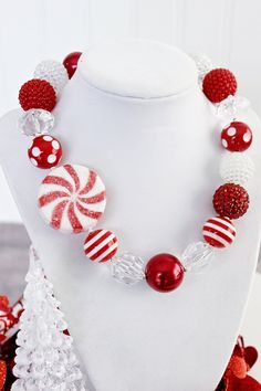 red and white candy bead necklace on mannequins with christmas tree decoration