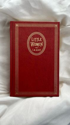 a little women book laying on top of a bed