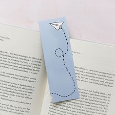 an open book with a paper airplane on it