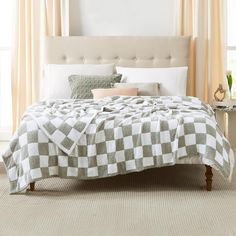 a bed with a checkered blanket and pillows