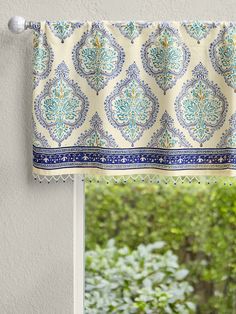 an open window with a blue and white patterned valance hanging from it's side