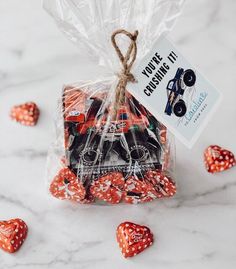 a bag filled with red dices sitting on top of a marble counter next to hearts