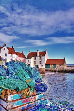 there are many fishing nets on the side of this boat in the water near some houses